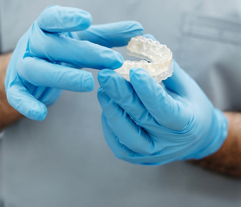 Close-up of a dentist holding a mold of teeth