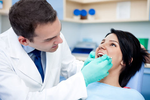 Male dentist with his female patient, teeth whitening treatment in-office