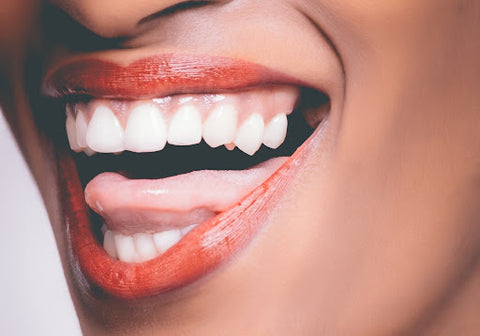 closeup of a young woman's teeth and tongue while smiling