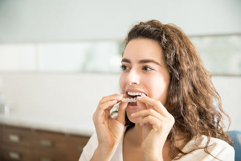 things to consider when choosing a retainer (young woman putting a retainer into her mouth)