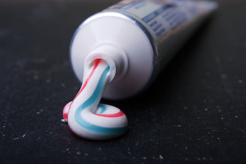 striped toothpaste squeezing out of a tube