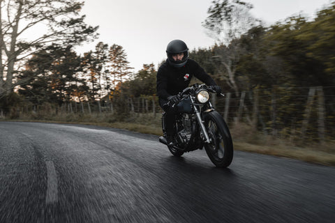 MOTORCYCLIST RIDING THROUGH WOODS