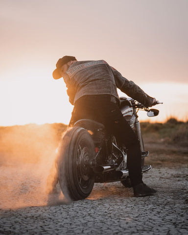 Man doing a tire burnout on his motorcycle in the sunset