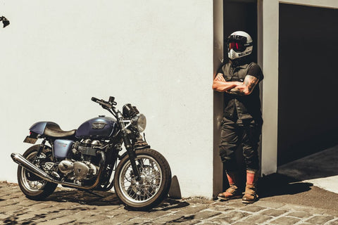 guy arms crossed beside his motorbike