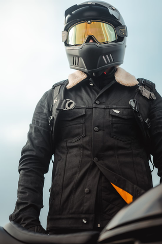 man wearing a motorcycle helmet and motorcycle jacket while sitting on a motorbike