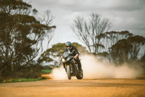 motorcycle rider on dirt with trees