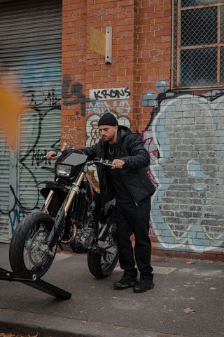 person wheeling bike onto vehicle