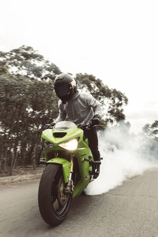 man riding a green motorcycle