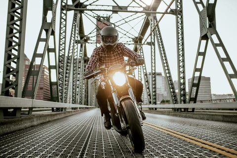 motorcyclist riding towards the camera with headlights on