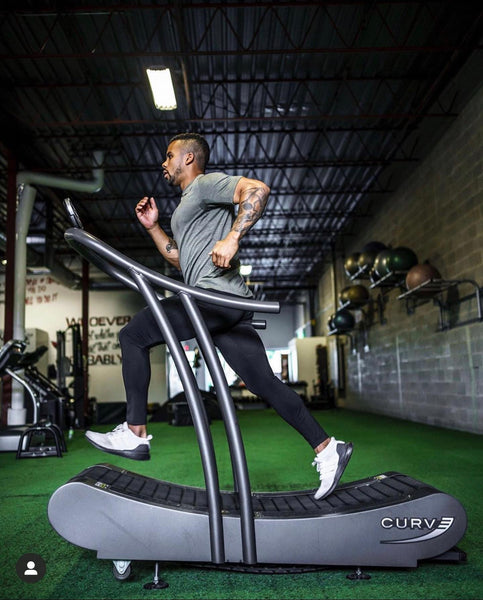 Man running on a woodway curved treadmill