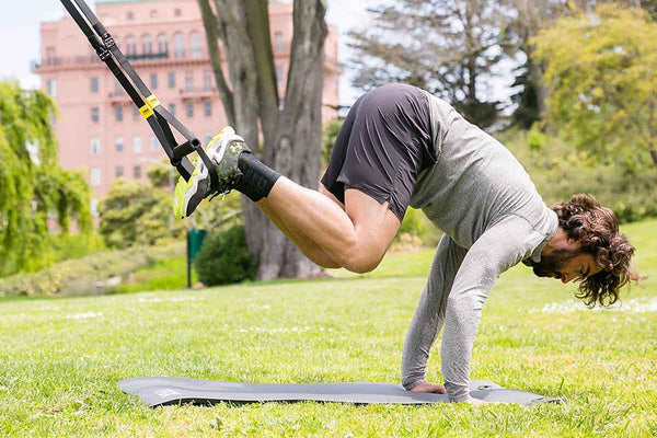 TRX workout outdoors. Man suspension training