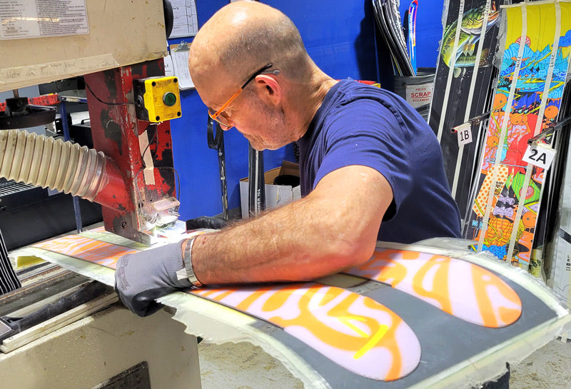 Martin cutting out a pair of j skis at the factory