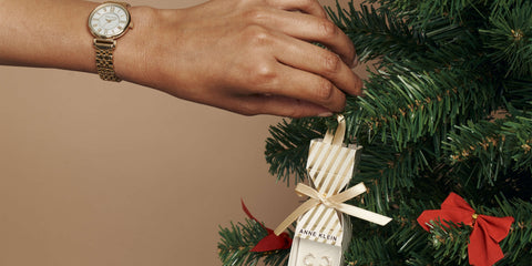 Hand hanging an Anne Klein jewelry set on Christmas tree 