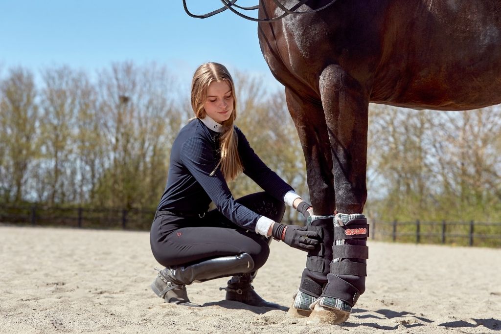 Ung kvinde giver sin hest Siccaro Sahara multifunktionelle tørregamacher på benene