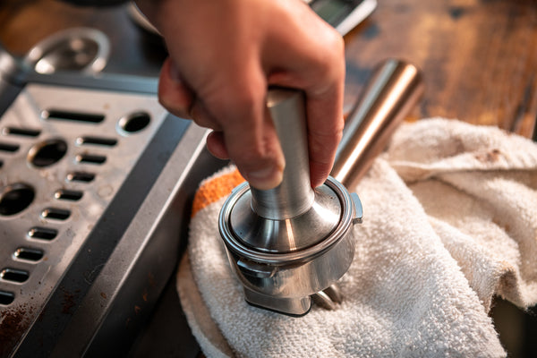 tamping espresso in portafilter for brewing