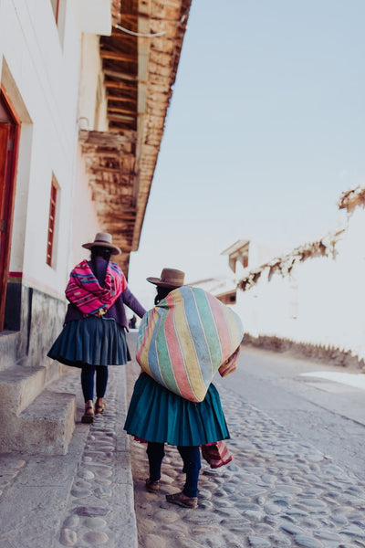 Women in peru carrying sacks of coffee beans