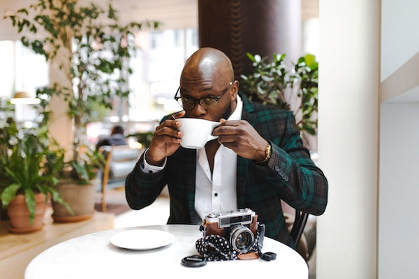 man drinking and enjoying a cup of honey processed coffee in a cafe