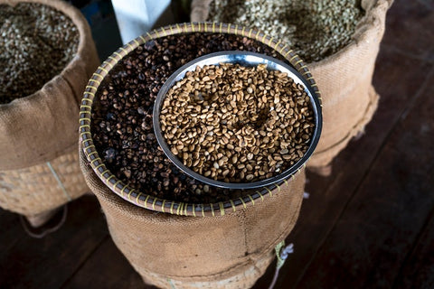 Assortment of Roasted and Unroasted coffee beans in wicker baskets and bowls