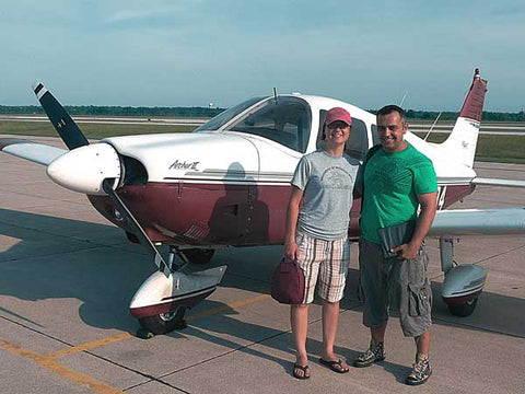Pilot and passenger in front of small plane