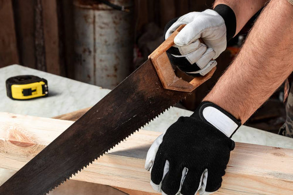carpenter-cuts-a-wooden-beam-using-a-handsaw