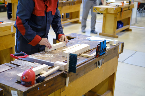 man-puts-piece-of-wood-on-workbench