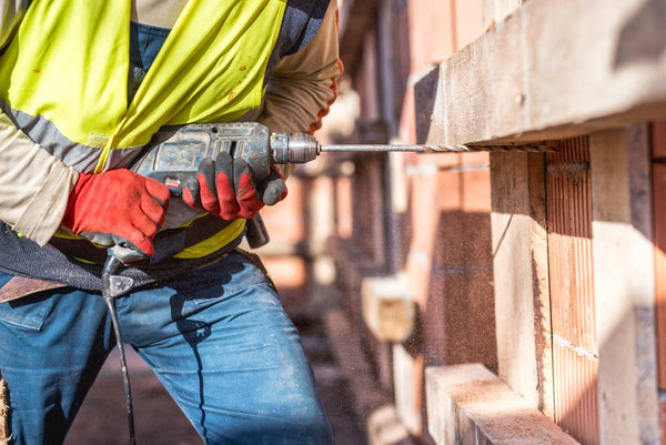 worker using a drilling corded tool