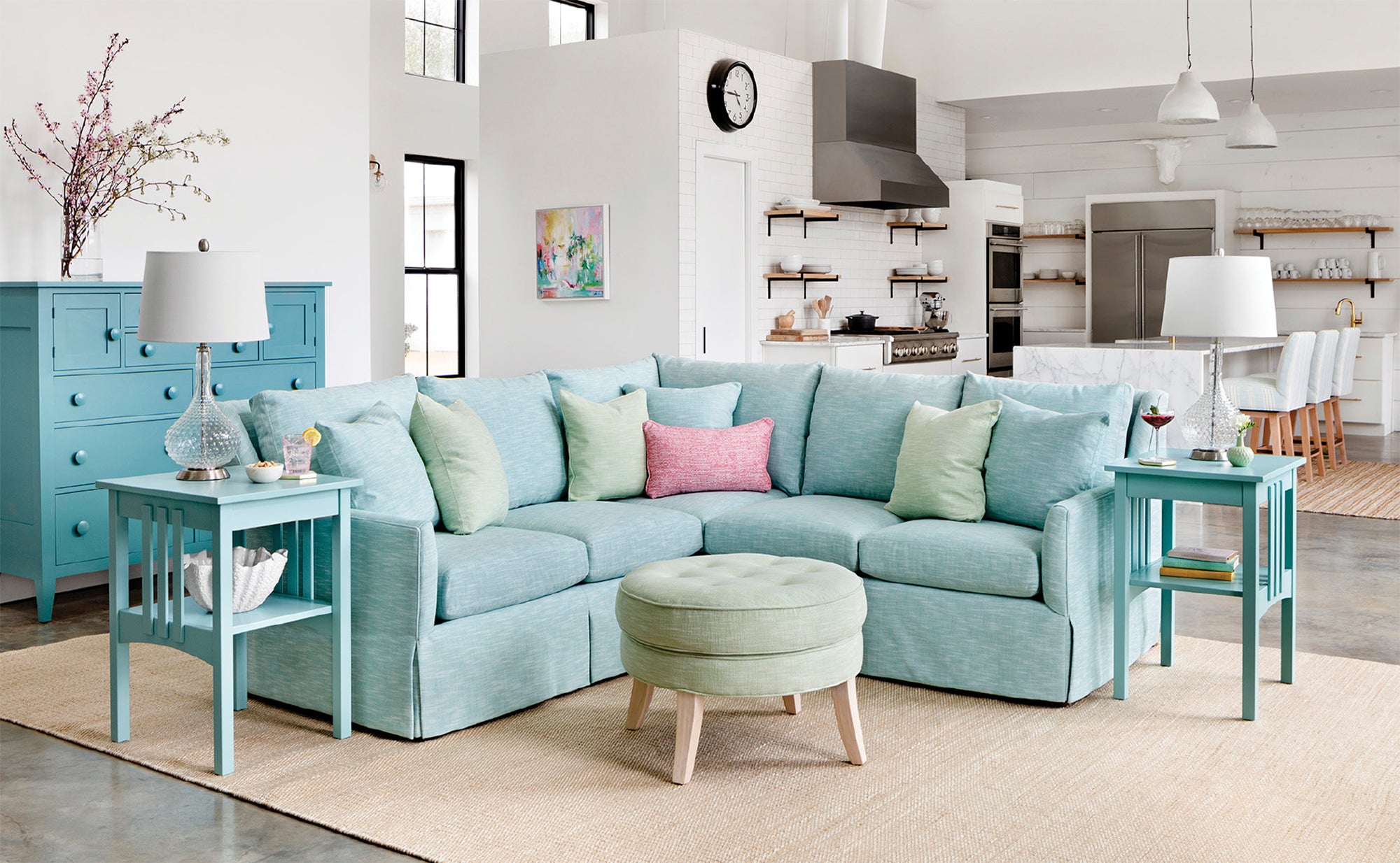 Vera loveseat sectional and side tables in turquoise, Eloise ottoman, dresser in Surf, Carrie lamps, Pebble Natural rug
