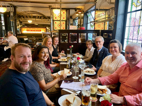 A group of 8 people sat around a table at Whitelocks Ale House eating fish finger sandwiches on a food tour. This is one of the best things to do in Leeds City Centre