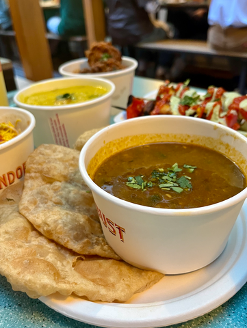 A pot of Dahl with paratha, and some other Indian street food pots out of focus in the background, at Bundobust, one of the vegetarian restaurants in Leeds