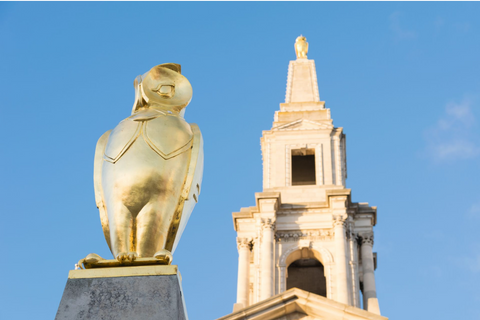A gold owl statue with a blue sky behind it, part of the Leeds owl trail. This is one of the free things to do in leeds city centre