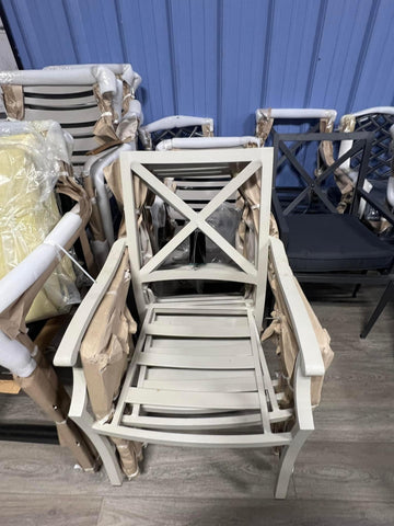 Stack of White Metal Chairs with x-pattern back on hard-wood floor.