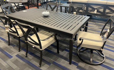 Black cast-aluminum rectangular table, 4 dining chairs, and 2 swivel chairs at each end with beige cushions.