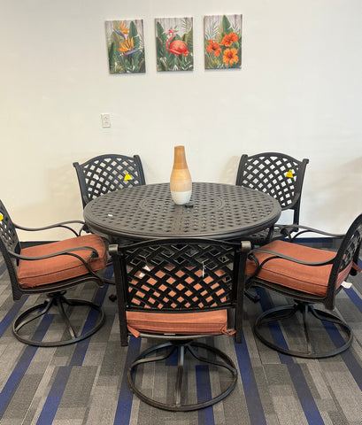 52" round black cast aluminum table surrounded by weave pattern swivel chairs with brown cushions