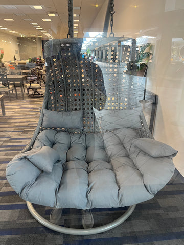 Swinging loveseat with teal cushion viewed through glass of Flamingo Patio store at Eastview Mall in Rochester NY