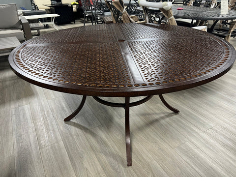 64" round aluminum table, color of dark red sand.  On grey hard-wood floor