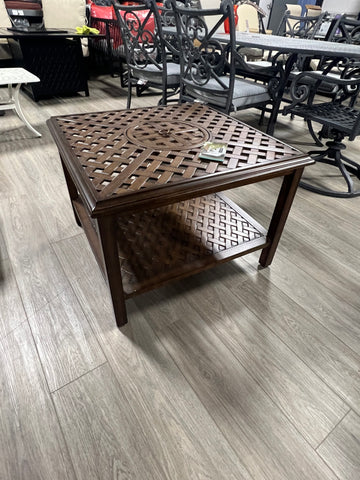 Small brown aluminum square ice-bucket table on hardwood floor.