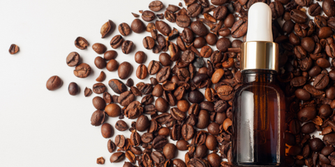 A brown glass bottle with a pipette rests on coffee beans. White background in combination with roasted coffee beans and cosmetics. Cosmetic, skin care, relaxation concept