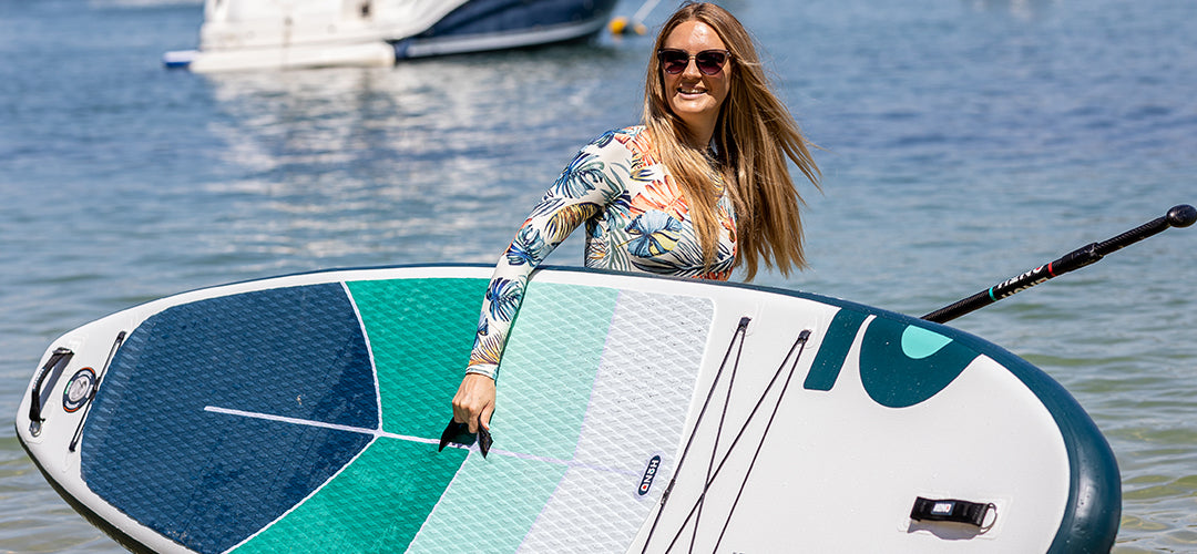 A woman carrying her paddleboard