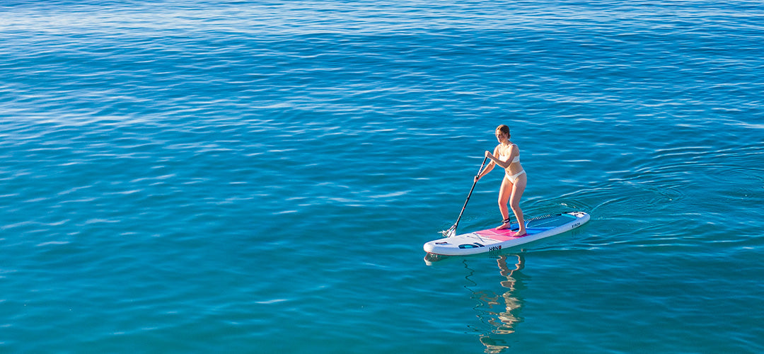 A woman stand up paddleboarding