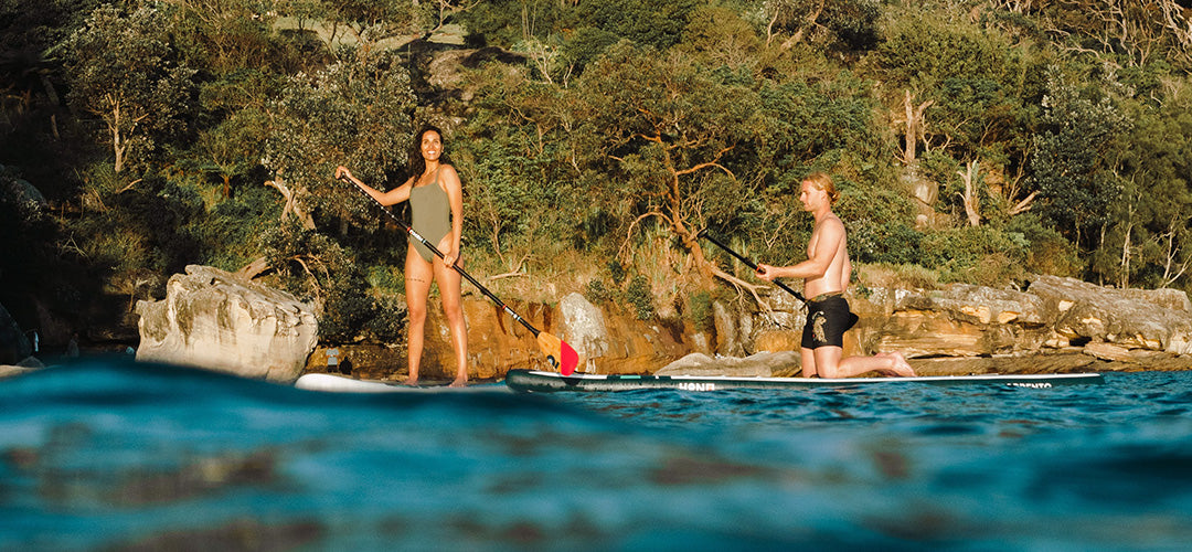 A man and woman enjoying their time on their stand up paddleboards