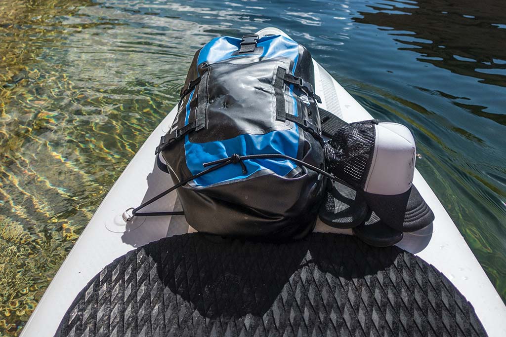 A bag strapped by the bungee straps of a stand up paddleboard