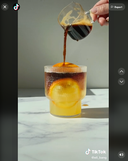 espresso poured into a cup of tonic water with an orange slice