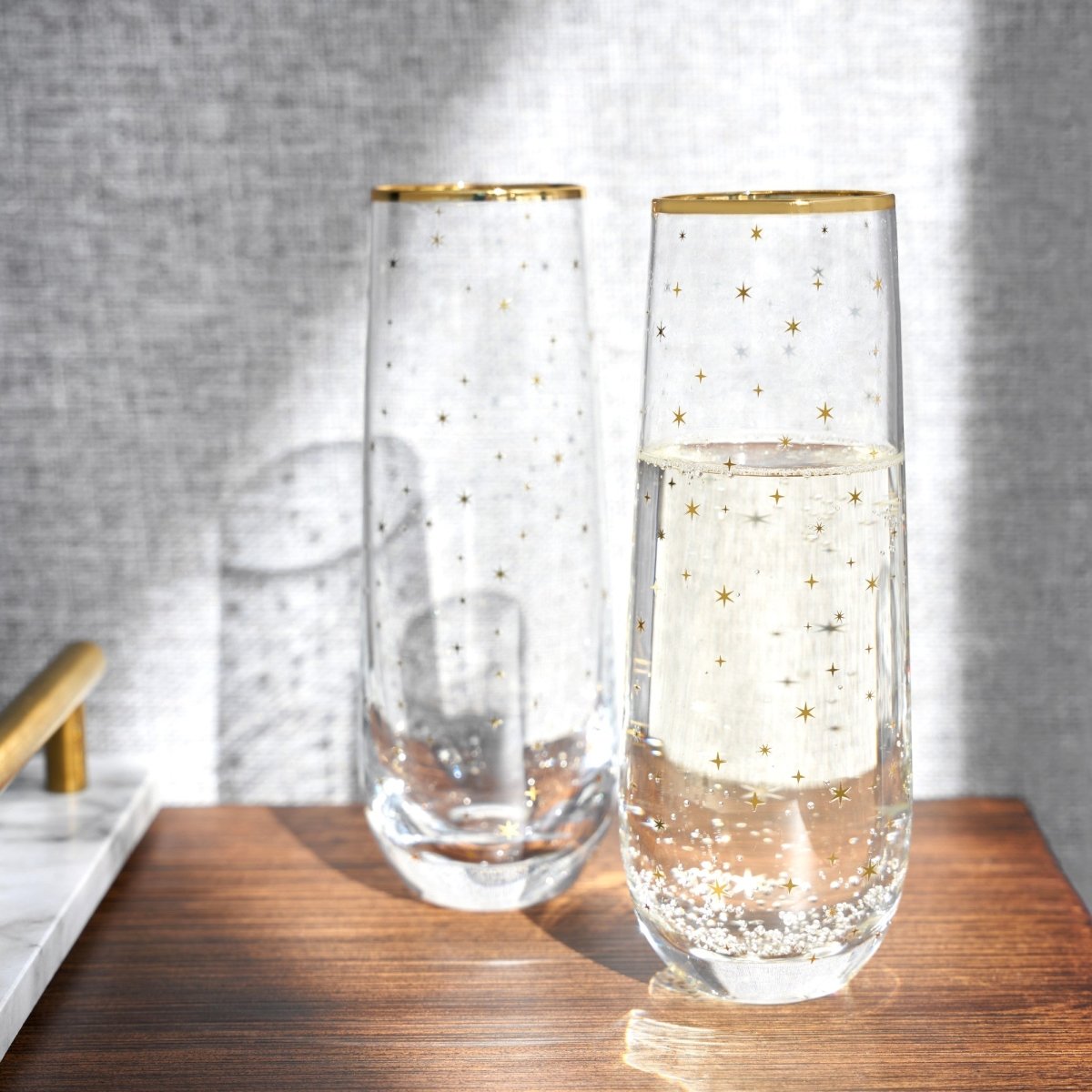 https://cdn.shopify.com/s/files/1/0275/1876/3088/products/starlight-stemless-champagne-flute-set-of-2-802724_1445x.jpg?v=1667362752