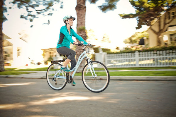 A woman riding a bike while wearing protective clothing