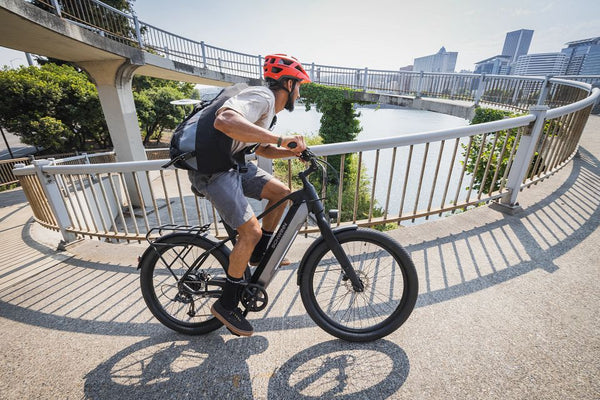 Man riding a commuter electric bike up a ramp.