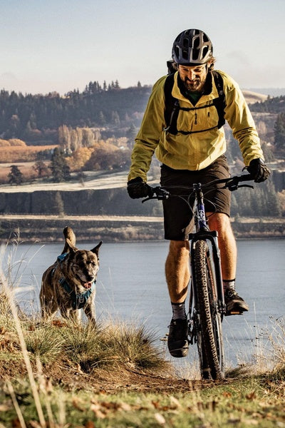 A man and his dog riding through the hills