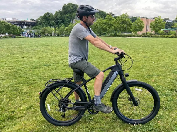 Man standing with his Schwinn Coston DX e-bike.