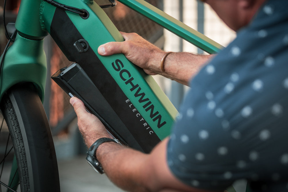 A man removing the battery from his electric bike.