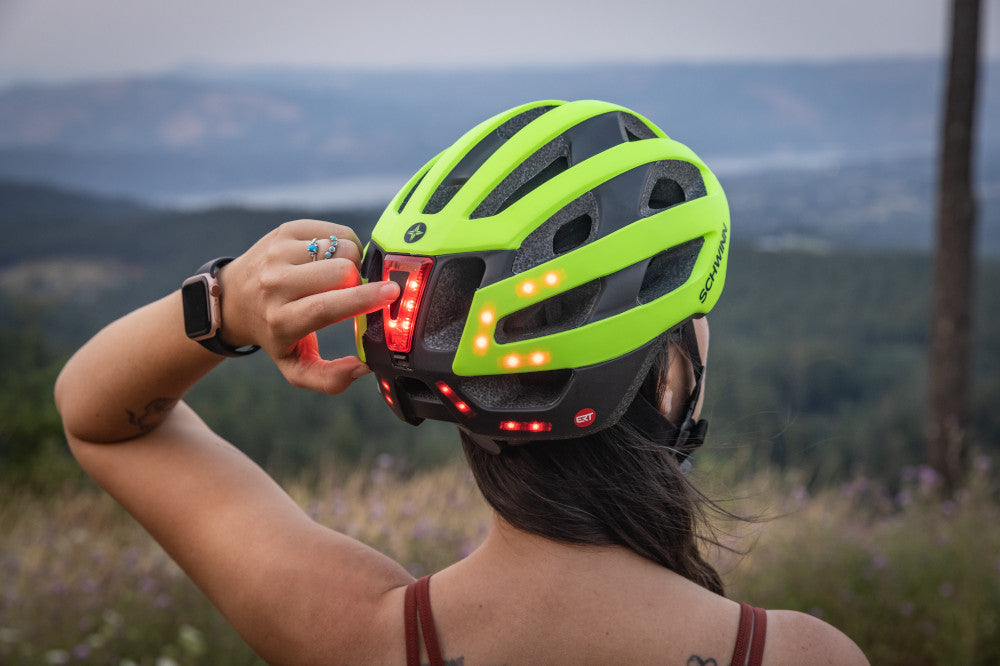 Woman turning on a light up bike helmet.