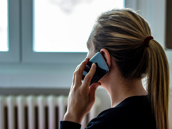 a woman with blonde hair speaking on a phone